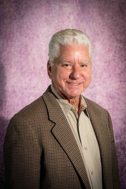 Headshot of BOT Member J. Keith Arnold on a purple background.