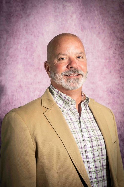 Headshot of BOT Member John Dulmer on a purple background.