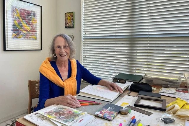 Artist Barbara Yeomans at her art table