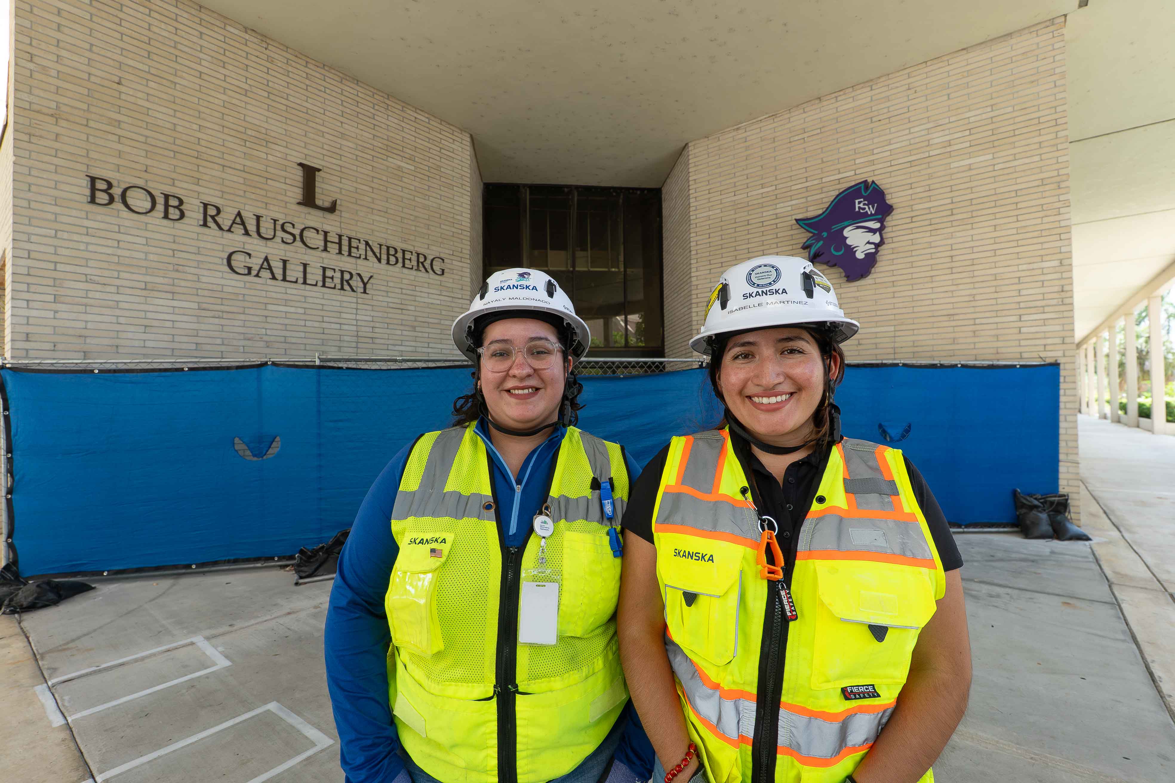 FSW alumna Nayaly Maldonado and former student Isabelle Martinez at the entrance of the Bob Rauschenberg Gallery.
