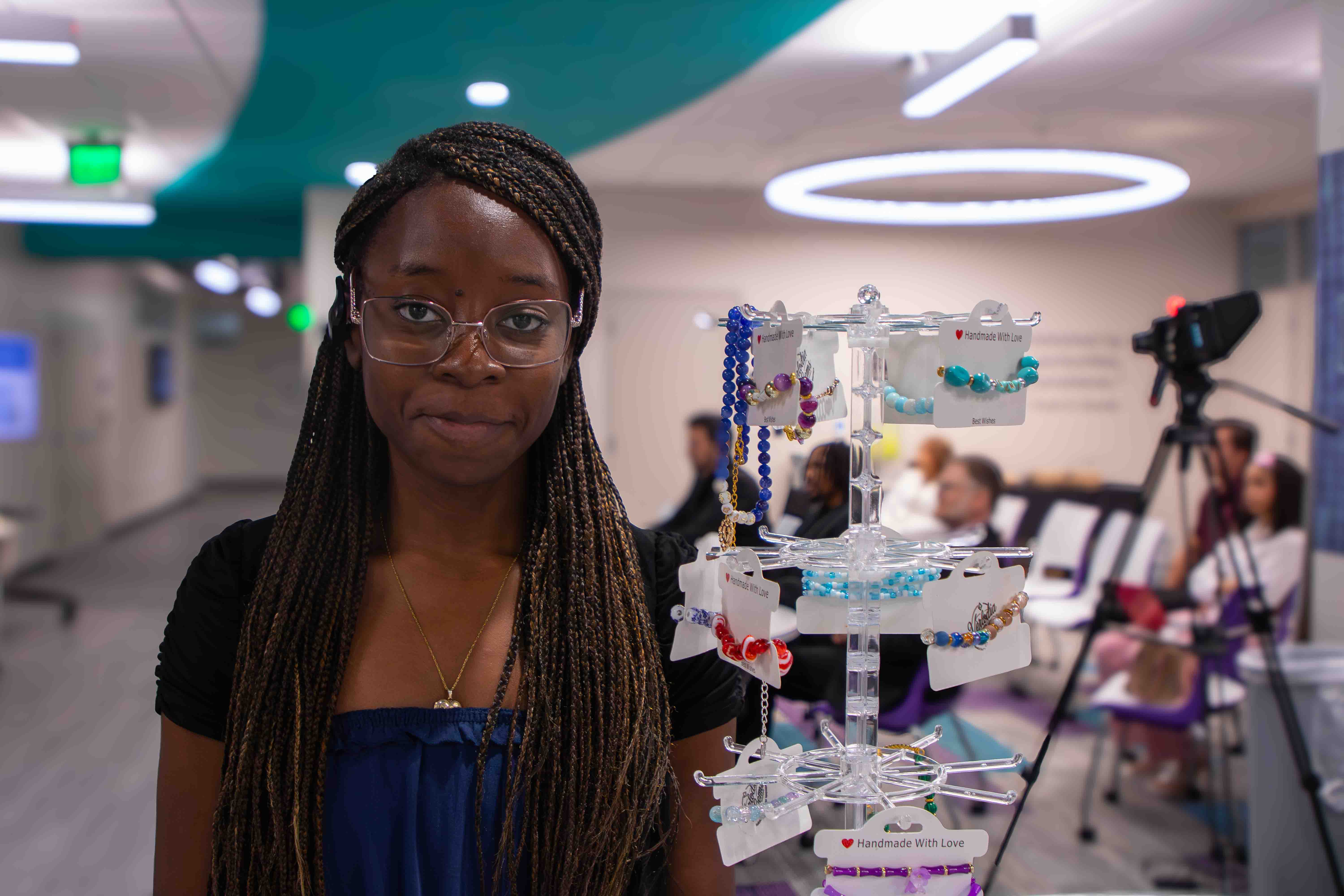 Victoria Hippolyte poses next to her project, Verlodia Gems, a customizable jewelry brand specializing in beaded pieces.