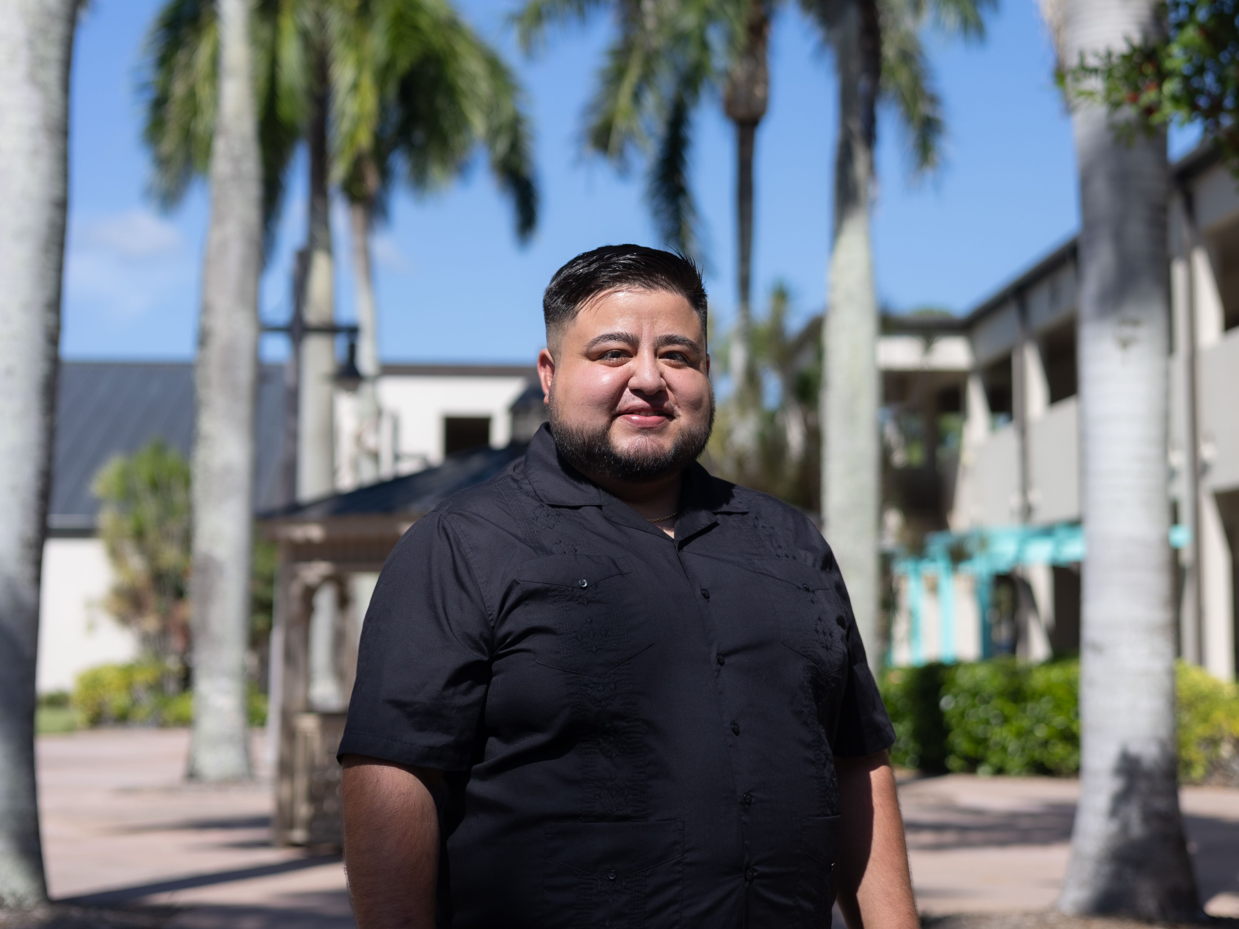 Photo of Collier Campus student, Rafael posing for photo  on the breeze way area on Collier Campus.