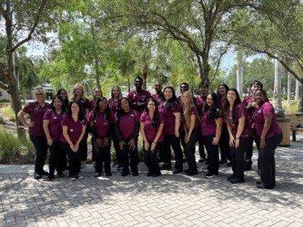 A group of FSW Respiratory Care students and faculty wearing burgundy scrubs pose together outdoors on campus.